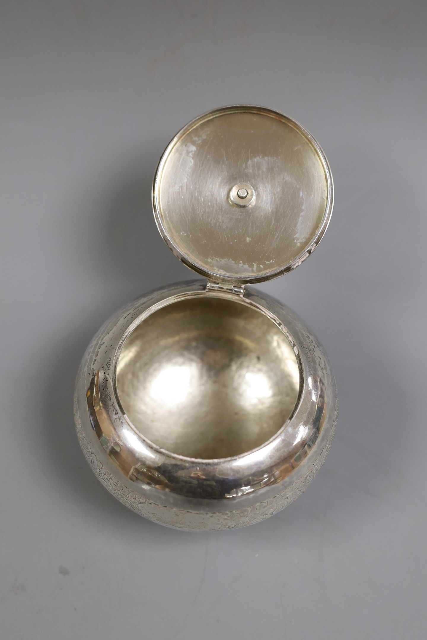 A George V engraved silver globular tea caddy, with carved stained wooden pineapple shaped knop, Goldsmiths & Silversmiths Co Ltd, London, 1920, height 11.3cm, gross weight 12oz.